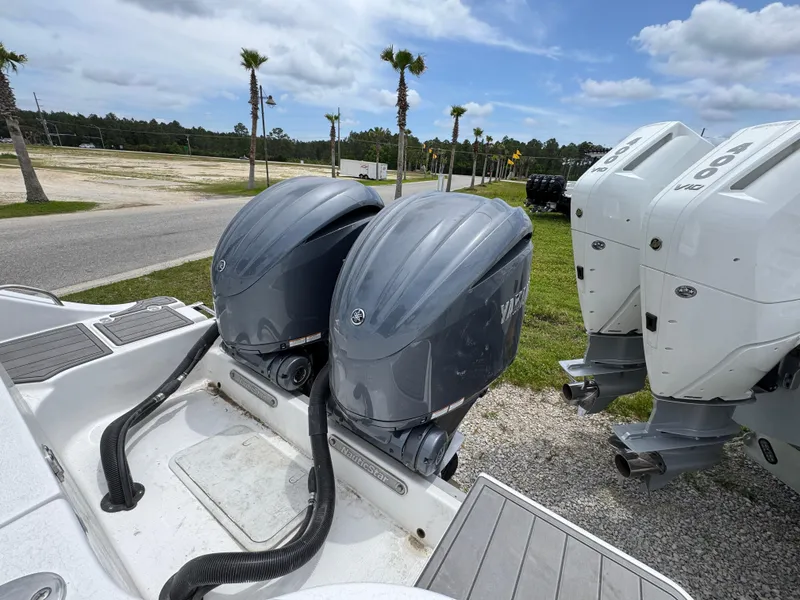 Slide: The Image of 2025 NauticStar 292 Legacy with dual outboard engines, parked outdoors. - 29
