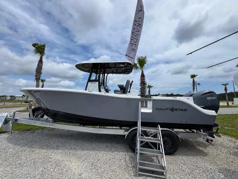 Slide: The Image of 2025 NauticStar 292 Legacy boat on trailer, displayed outdoors under cloudy sky. - 8