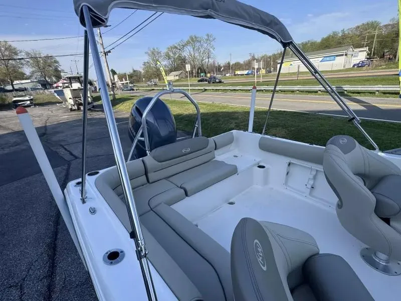 Slide: The Image of 2023 Key West 203 DFS boat with spacious seating and canopy, parked outdoors. - 14