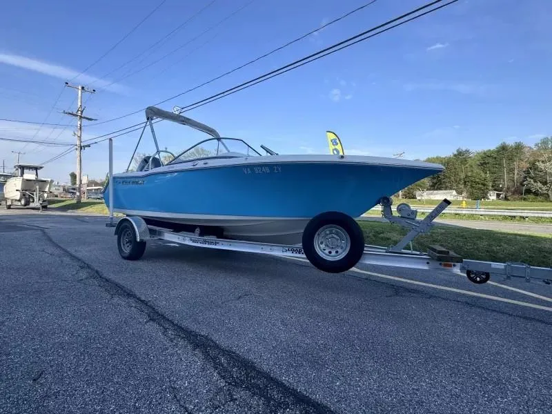 Slide: The Image of 2023 Key West 203 DFS boat on trailer, parked on roadside under clear blue sky. - 2