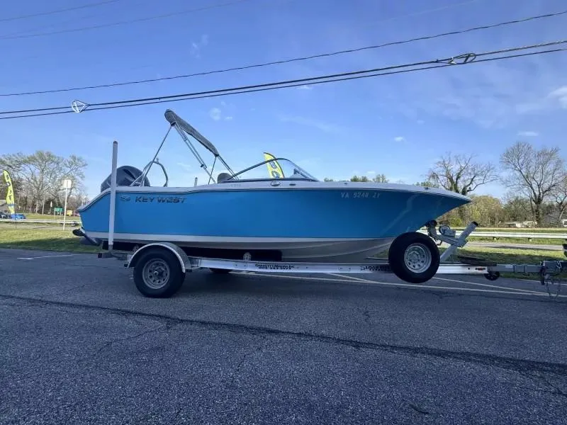 Slide: The Image of 2023 Key West 203 DFS boat on trailer, parked on roadside under clear sky. - 3