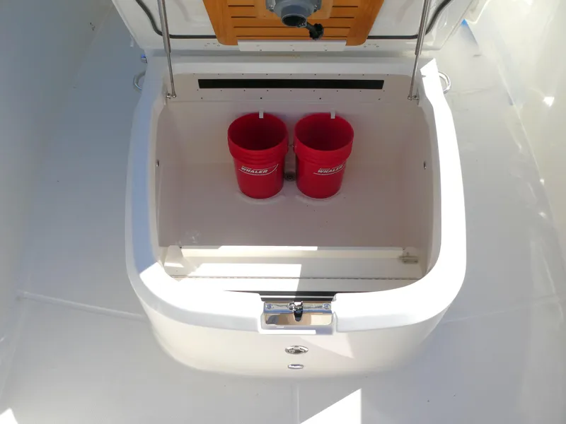Slide: The Image of Storage compartment on 2025 Boston Whaler 330 Outrage with red buckets inside. - 12