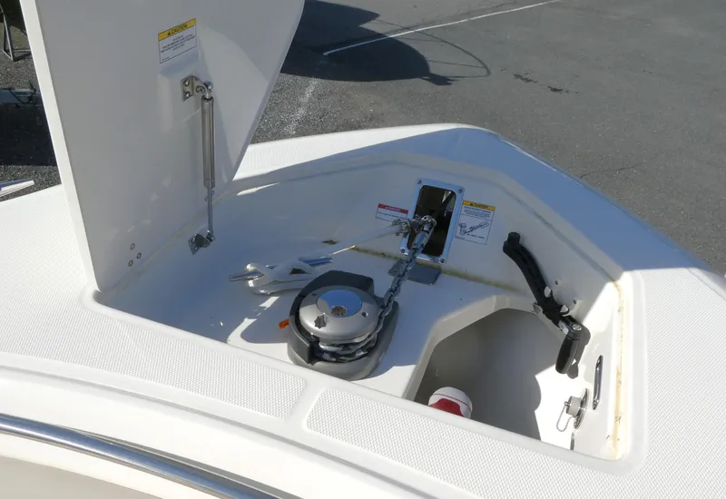 Slide: The Image of 2025 Boston Whaler 330 Outrage anchor compartment with winch and storage. - 15