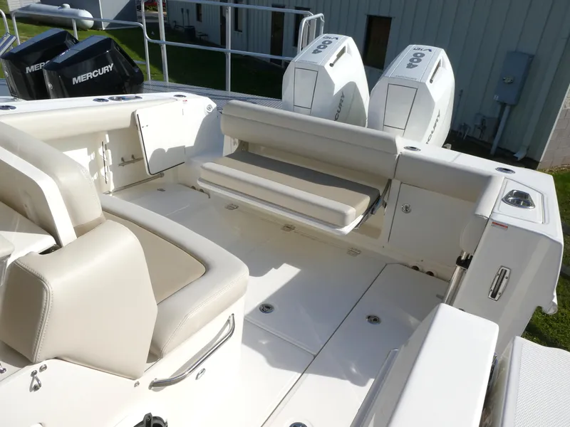 Slide: The Image of 2025 Boston Whaler 330 Outrage boat interior with seating and dual Mercury engines. - 5