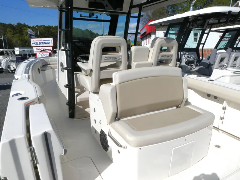 Slide: The Image of 2025 Boston Whaler 330 Outrage boat interior with beige seating and modern design. - 6