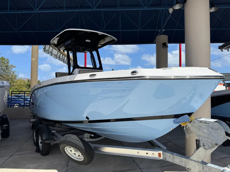 The Image of 2025 Yamaha Boats 222 FSH Sport E in light blue on trailer, under canopy. - 0