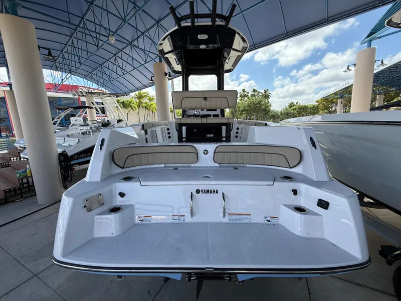 Slide: The Image of 2025 Yamaha Boats 222 FSH Sport E, rear view, under a canopy, showcasing seating and deck features. - 2
