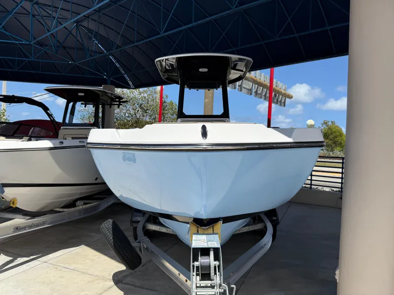 Slide: The Image of 2025 Yamaha Boats 222 FSH Sport E on trailer under canopy, front view. - 3