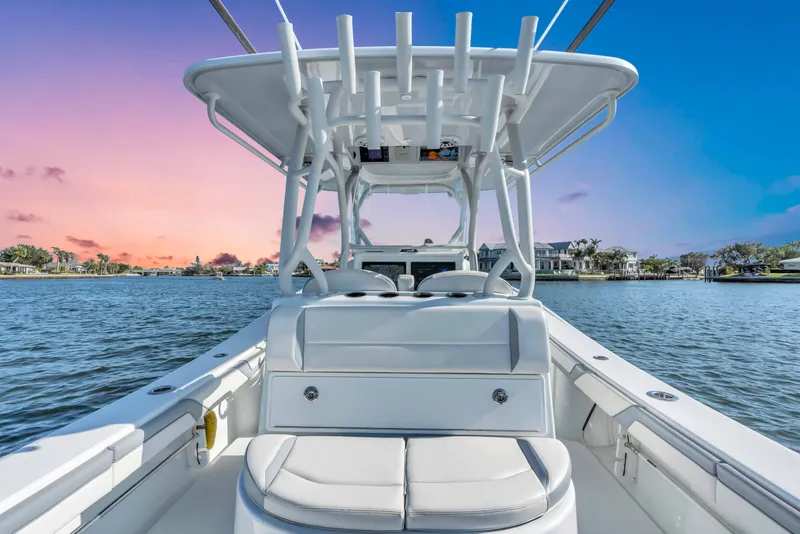 Slide: The Image of 2021 Yellowfin 36 Offshore boat on water at sunset, showcasing sleek design and spacious deck. - 16