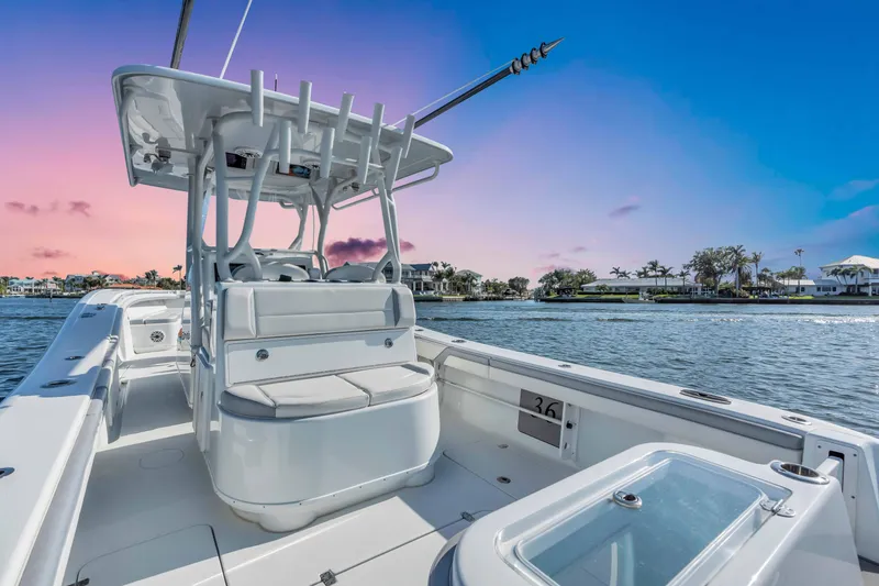 Slide: The Image of 2021 Yellowfin 36 Offshore boat on water at sunset, showcasing sleek design and spacious deck. - 18