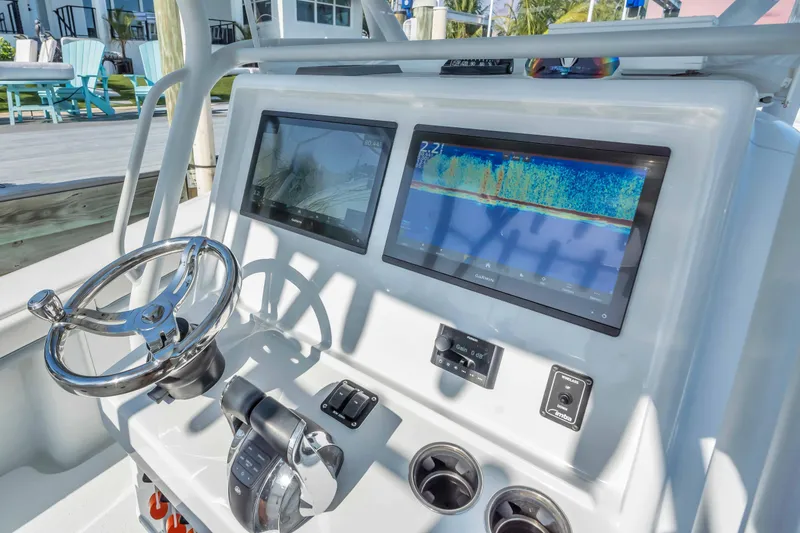 Slide: The Image of 2021 Yellowfin 36 Offshore boat dashboard with dual screens and steering wheel. - 19