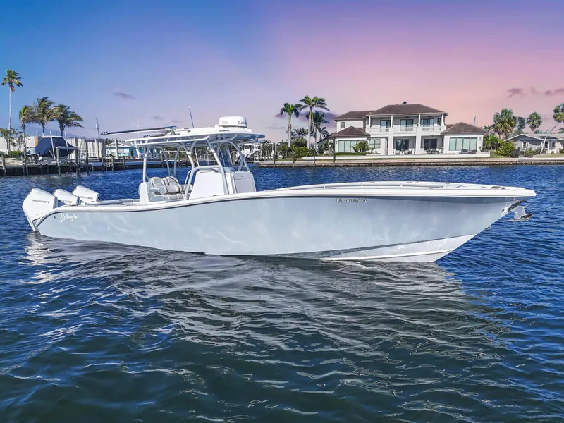 Slide: The Image of 2021 Yellowfin 36 Offshore boat on water, with coastal homes in the background. - 4