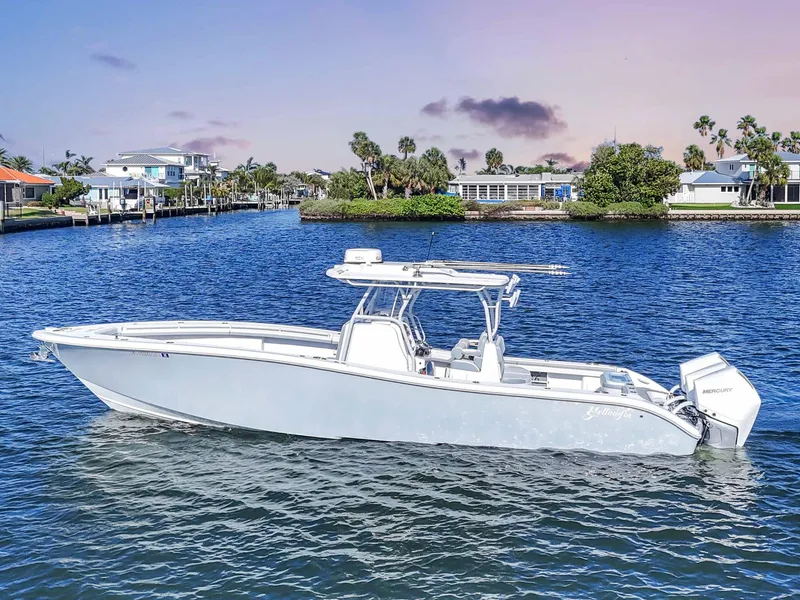 Slide: The Image of 2021 Yellowfin 36 Offshore boat on calm water, scenic coastal background. - 6