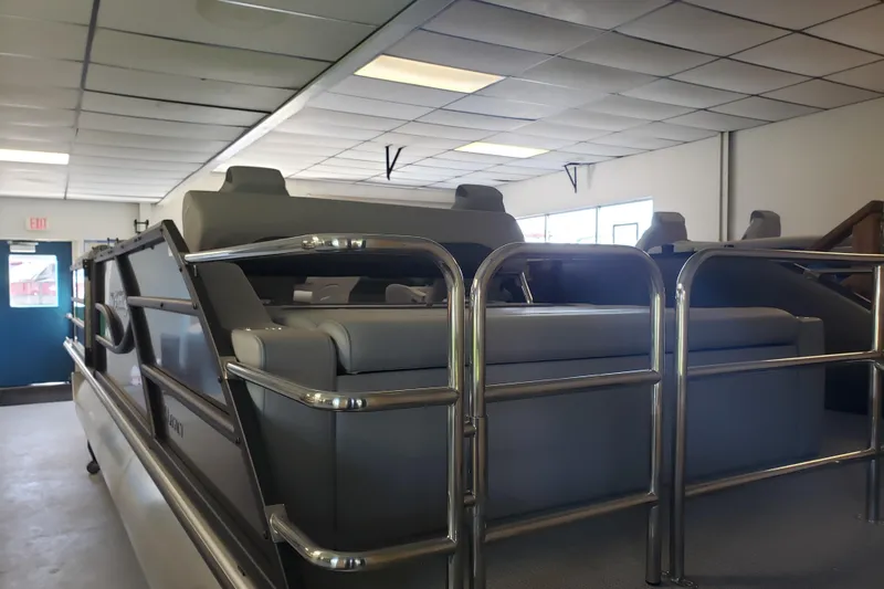 Slide: The Image of 2025 Bentley Pontoons Legacy Swingback in showroom, featuring sleek design and comfortable seating. - 3