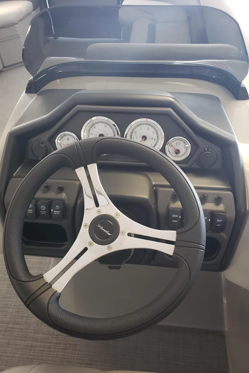 Slide: The Image of 2025 Bentley Pontoons Legacy Swingback dashboard with steering wheel and gauges. - 6