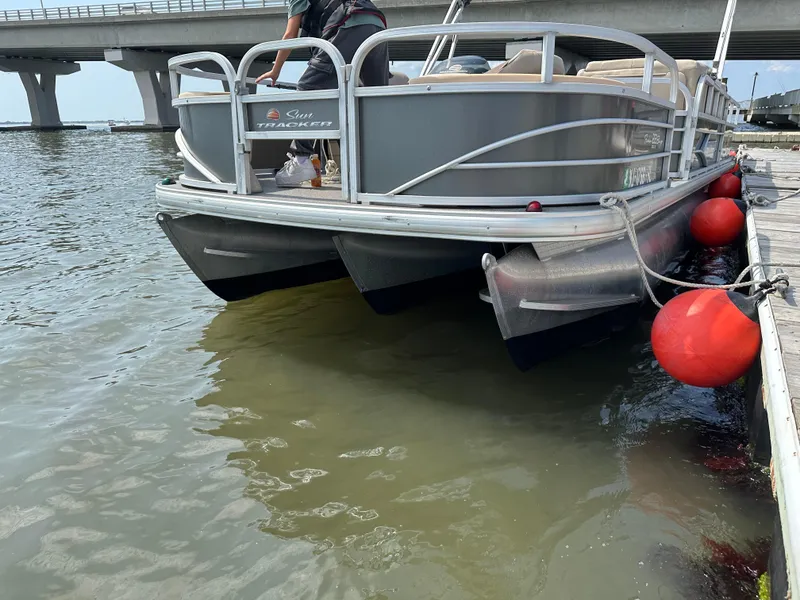 Slide: The Image of 2018 Sun Tracker Fishing Barge 22 docked near a bridge with red buoys. - 15