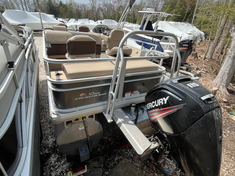 Slide: The Image of 2018 Sun Tracker Fishing Barge 22 with Mercury outboard motor, parked outdoors. - 3