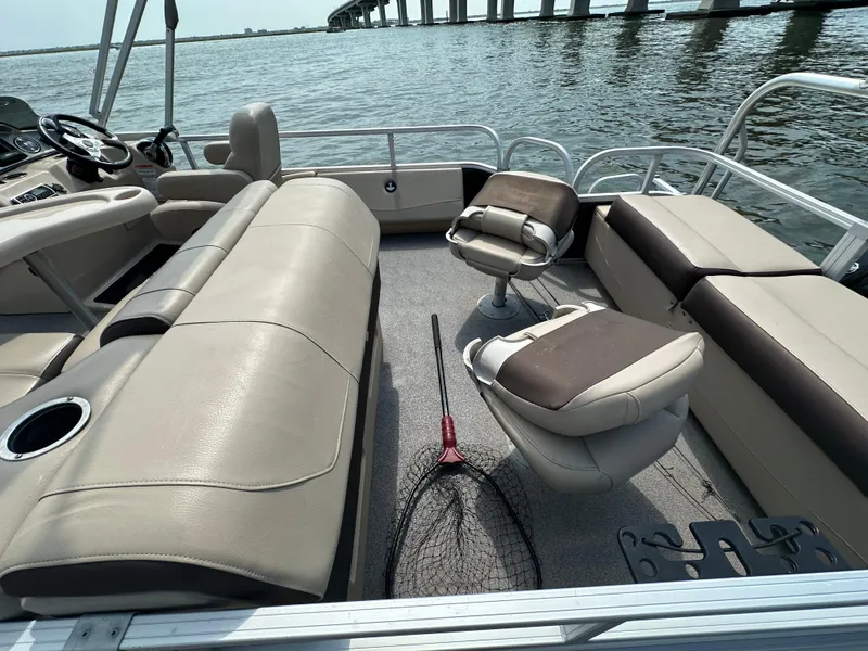 Slide: The Image of 2018 Sun Tracker Fishing Barge 22 interior with seating and fishing net on deck. - 8