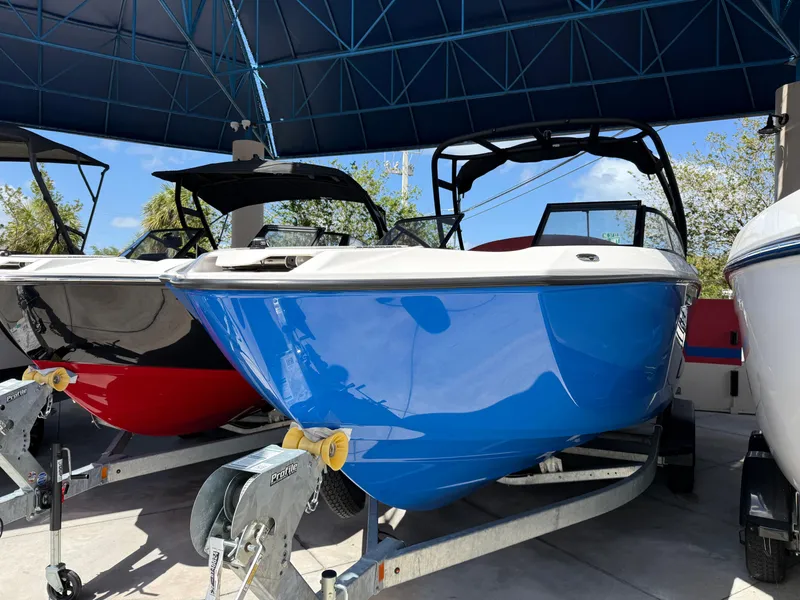 Slide: The Image of 2025 Yamaha Boats AR250 in blue, displayed on a trailer under a canopy. - 12