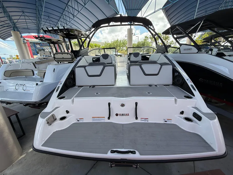 Slide: The Image of 2025 Yamaha Boats AR250, sleek design, spacious seating, modern features, docked under canopy. - 3