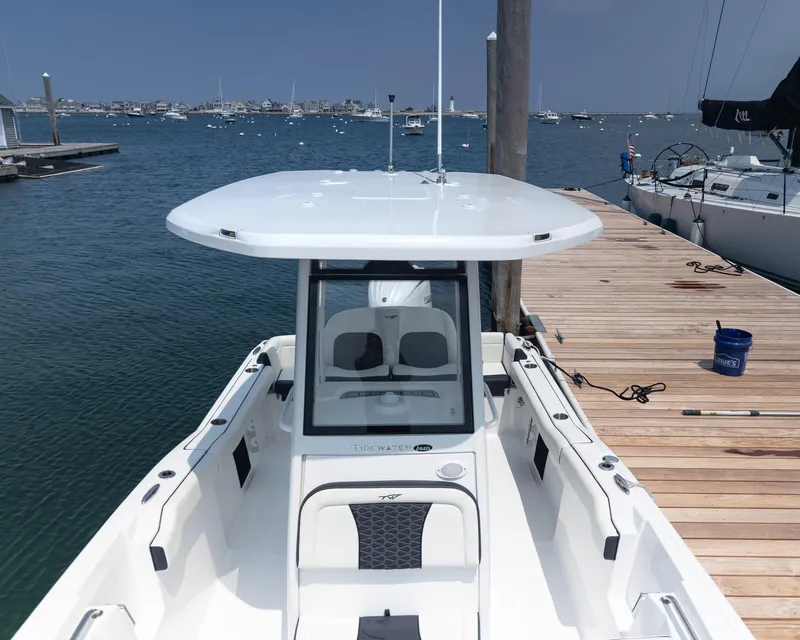 Slide: The Image of 2025 Tidewater 230 LXF boat docked at marina, featuring sleek design and spacious deck. - 13