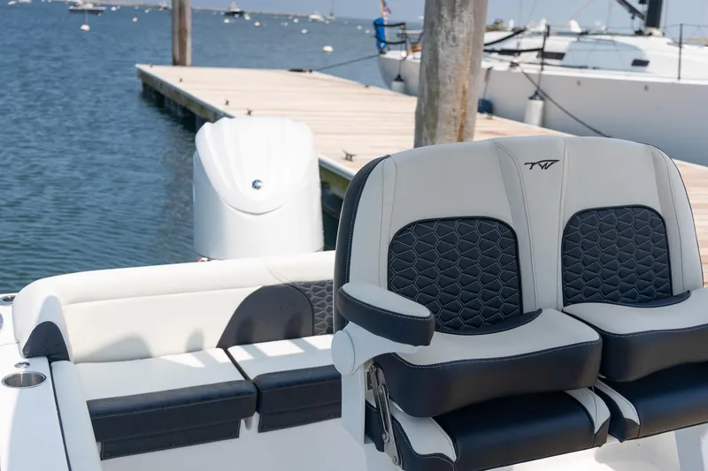 Slide: The Image of 2025 Tidewater 230 LXF boat interior with stylish seating near a dock. - 17
