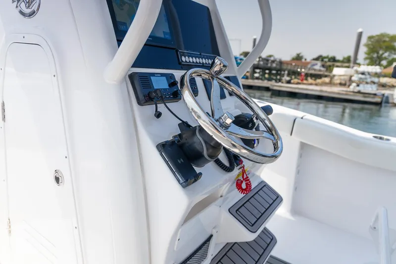 Slide: The Image of 2025 Tidewater 230 LXF boat helm with modern controls and steering wheel. - 21