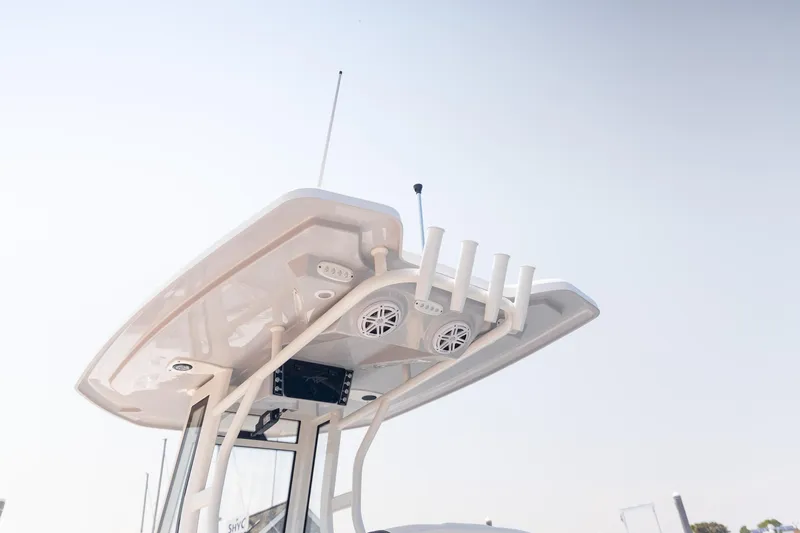 Slide: The Image of 2025 Tidewater 230 LXF boat with T-top and rod holders against clear sky. - 22