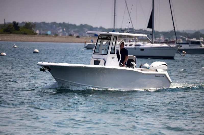 Slide: The Image of 2025 Tidewater 230 LXF boat cruising on a calm sea with other boats in the background. - 27