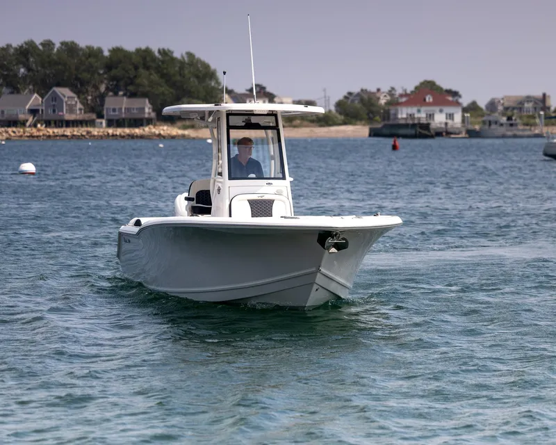Slide: The Image of 2025 Tidewater 230 LXF boat cruising on a calm coastal waterway. - 3