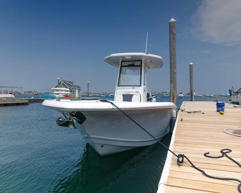 Slide: The Image of 2025 Tidewater 230 LXF boat docked at a marina under a clear blue sky. - 5