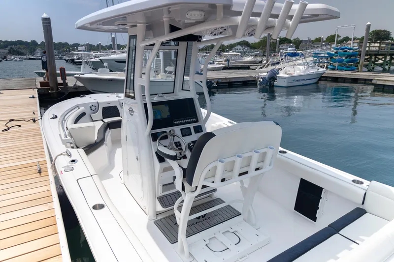 Slide: The Image of 2025 Tidewater 230 LXF boat docked at marina, featuring modern helm and seating. - 8