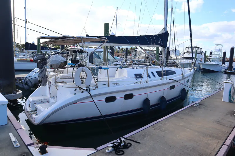 Slide: The Image of 1997 Hunter 37 sailboat docked at marina, featuring sleek design and spacious deck. - 1