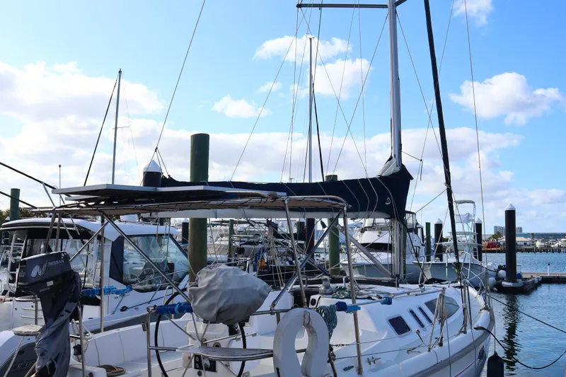 Slide: The Image of 1997 Hunter 37 sailboat docked at a marina under a clear blue sky. - 10
