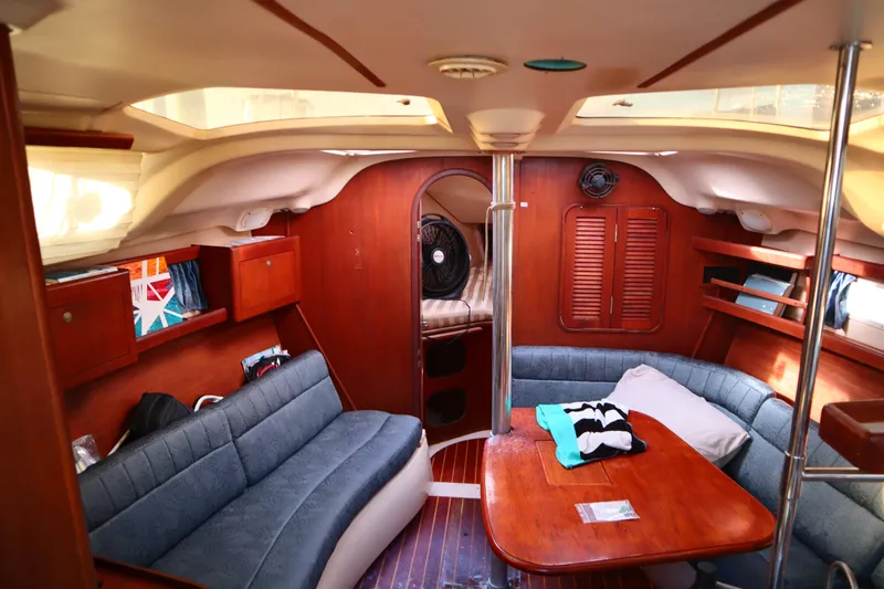 Slide: The Image of Interior of a 1997 Hunter 37 sailboat with cozy seating and wooden finishes. - 15