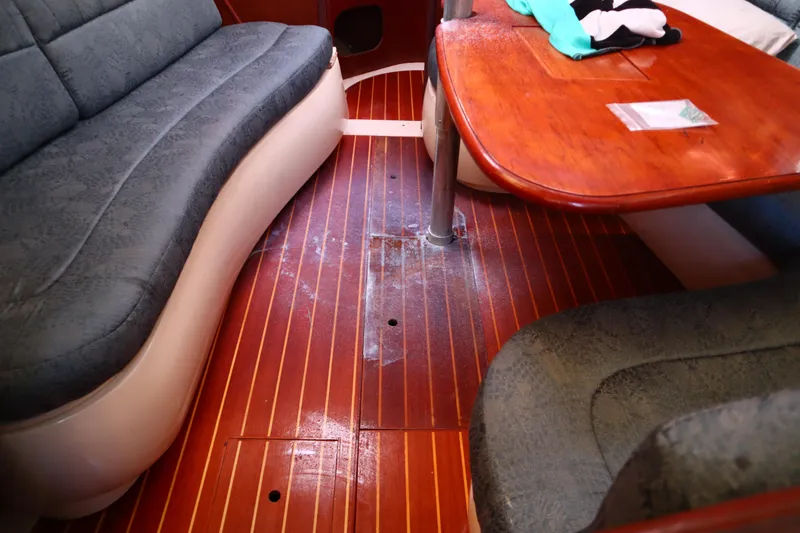 Slide: The Image of Interior of a 1997 Hunter 37 sailboat with wooden flooring and cushioned seating. - 16
