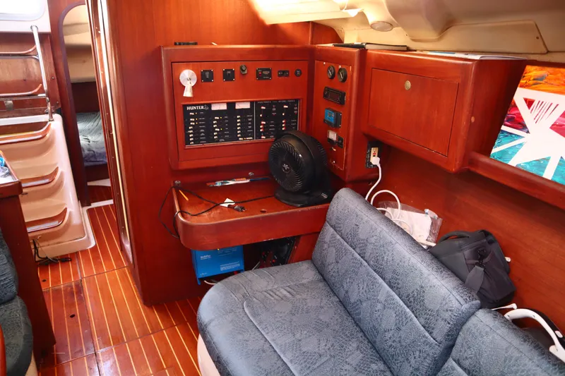 Slide: The Image of Interior of a 1997 Hunter 37 sailboat with control panel and seating area. - 19
