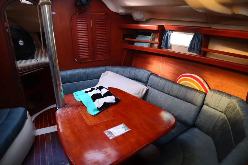 Slide: The Image of 1997 Hunter 37 sailboat interior with cozy seating and wooden table. - 25