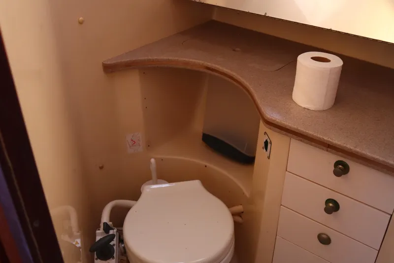 Slide: The Image of 1997 Hunter 37 yacht bathroom with toilet, countertop, and storage drawers. - 29