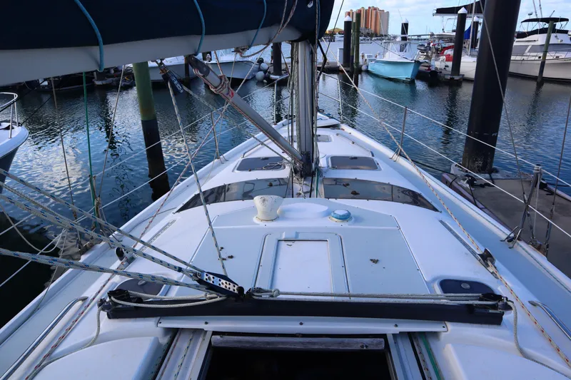 Slide: The Image of 1997 Hunter 37 sailboat deck view at marina, showcasing rigging and moored boats. - 3