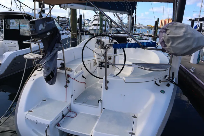 Slide: The Image of 1997 Hunter 37 sailboat cockpit with steering wheel, docked at marina. - 6
