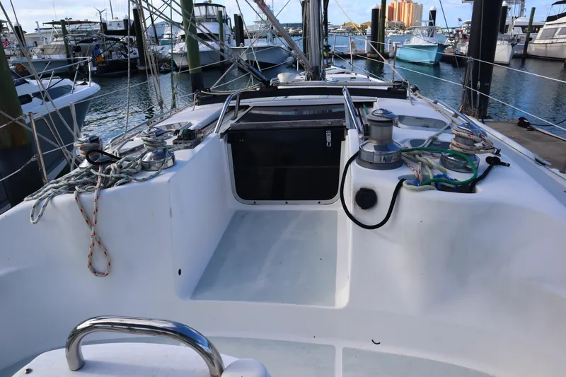 Slide: The Image of 1997 Hunter 37 sailboat cockpit with ropes and winches, docked at a marina. - 7