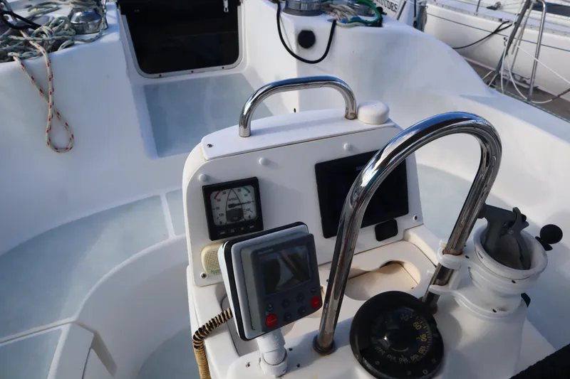 Slide: The Image of 1997 Hunter 37 sailboat cockpit with navigation instruments and steering wheel. - 9