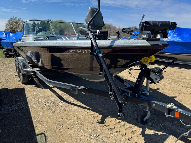 Slide: The Image of 2016 Tuffy Osprey 2100 boat on trailer, parked outdoors under clear sky. - 2