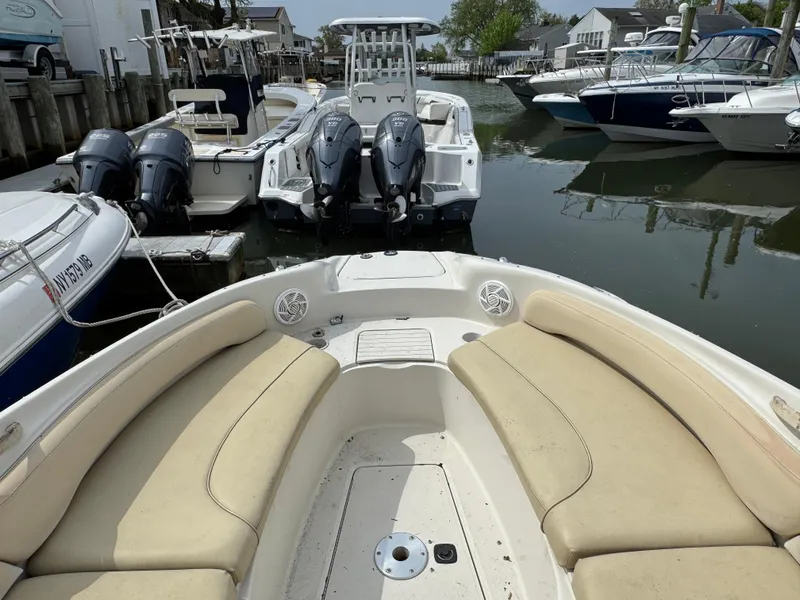 Slide: The Image of 2001 Sea Ray 240 Sundeck boat with beige seating, docked near other boats. - 14