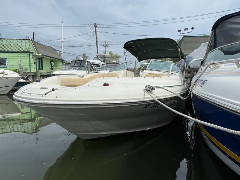 Slide: The Image of 2001 Sea Ray 240 Sundeck boat docked, featuring a sleek design and spacious seating. - 15