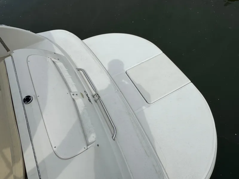 Slide: The Image of 2001 Sea Ray 240 Sundeck boat deck, white surface, near water. - 16