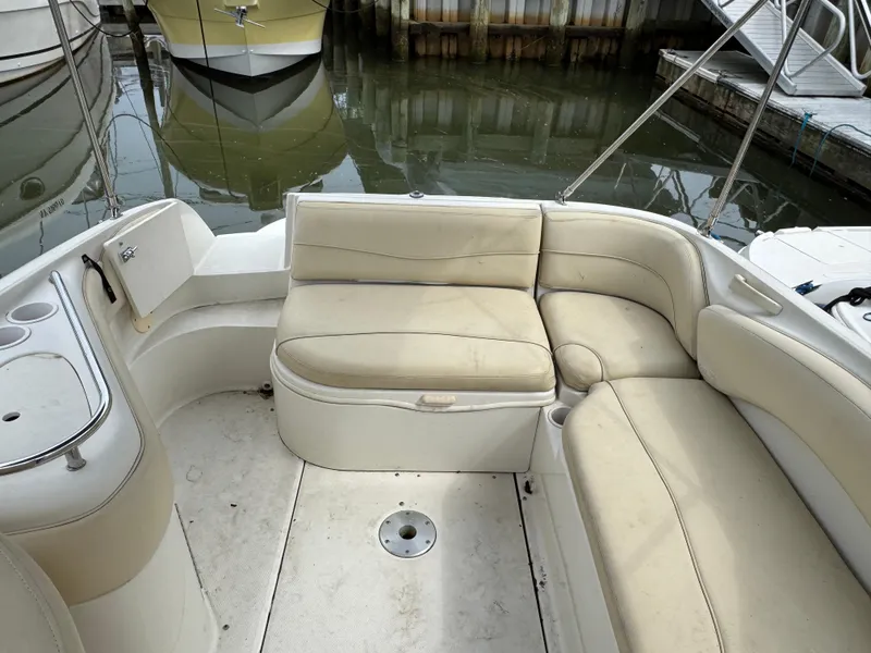 Slide: The Image of 2001 Sea Ray 240 Sundeck boat interior with beige seating and cup holders. - 5
