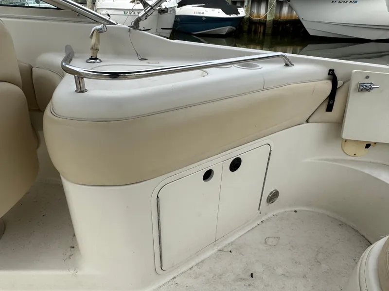 Slide: The Image of 2001 Sea Ray 240 Sundeck interior with beige seating and storage compartment. - 6
