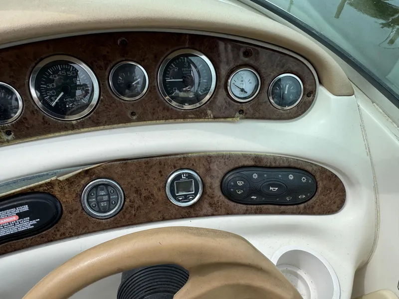 Slide: The Image of Dashboard of a 2001 Sea Ray 240 Sundeck boat with gauges and controls. - 9